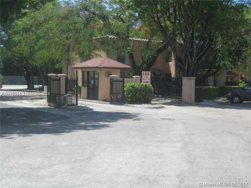 A gated entrance with a small guardhouse and metal fencing leads to a residential building — 10794 N Kendall Dr # B23, Miami FL 33176, MIAMI, FL
