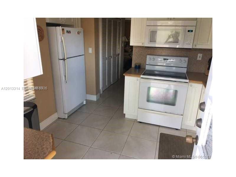 A kitchen features white appliances, light-colored cabinets, and tiled flooring — 10794 N Kendall Dr # B23, Miami FL 33176, MIAMI, FL