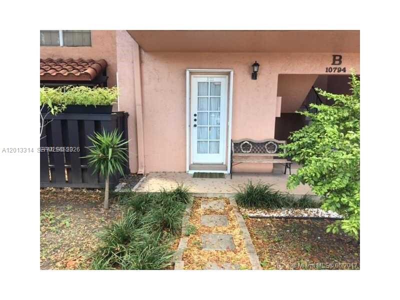 A white glass-paneled door sits under a covered entryway next to a metal bench — 10794 N Kendall Dr # B23, Miami FL 33176, MIAMI, FL