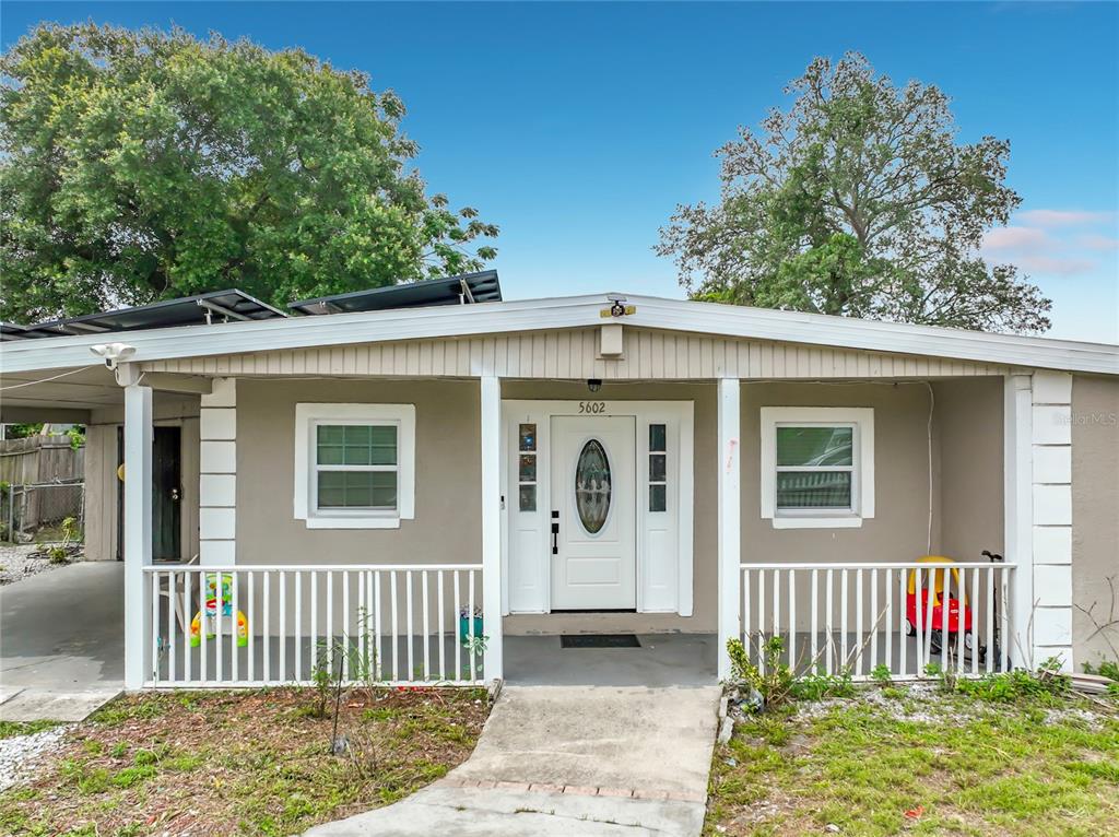 The exterior of a single-story house features a covered front porch with white railings — 5602 ASTORIA PLACE, ORLANDO, FL