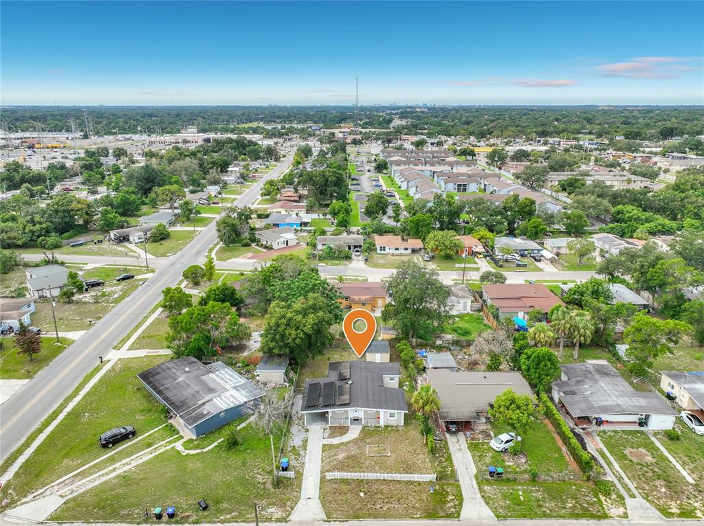 An aerial view shows a single-story house with solar panels and a detached garage — 5602 ASTORIA PLACE, ORLANDO, FL