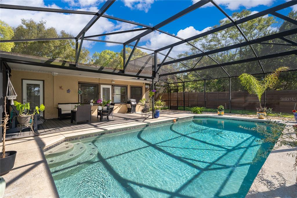 A screened-in patio features a swimming pool, a wooden deck, and a fenced backyard — 502 OAK LANE, MAITLAND, FL