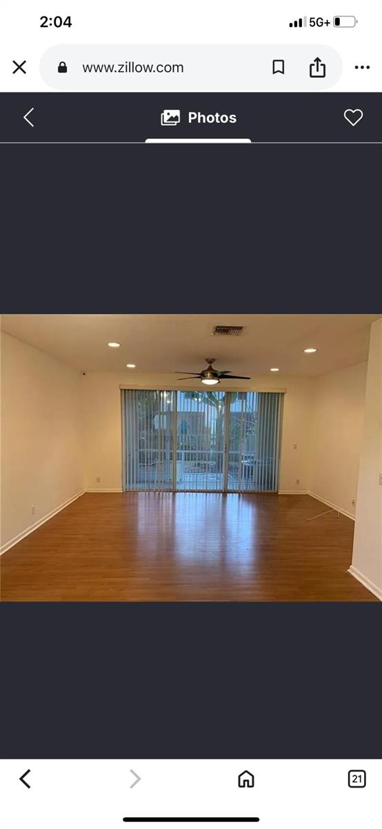 An empty room with hardwood floors, a ceiling fan, and sliding glass doors — 9772 Porta Leona Lane, Boynton Beach FL 33472, BOYNTON BEACH, FL