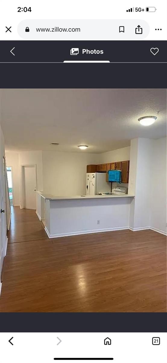 A view of a kitchen with wood cabinets and a breakfast bar overlooking a room — 9772 Porta Leona Lane, Boynton Beach FL 33472, BOYNTON BEACH, FL