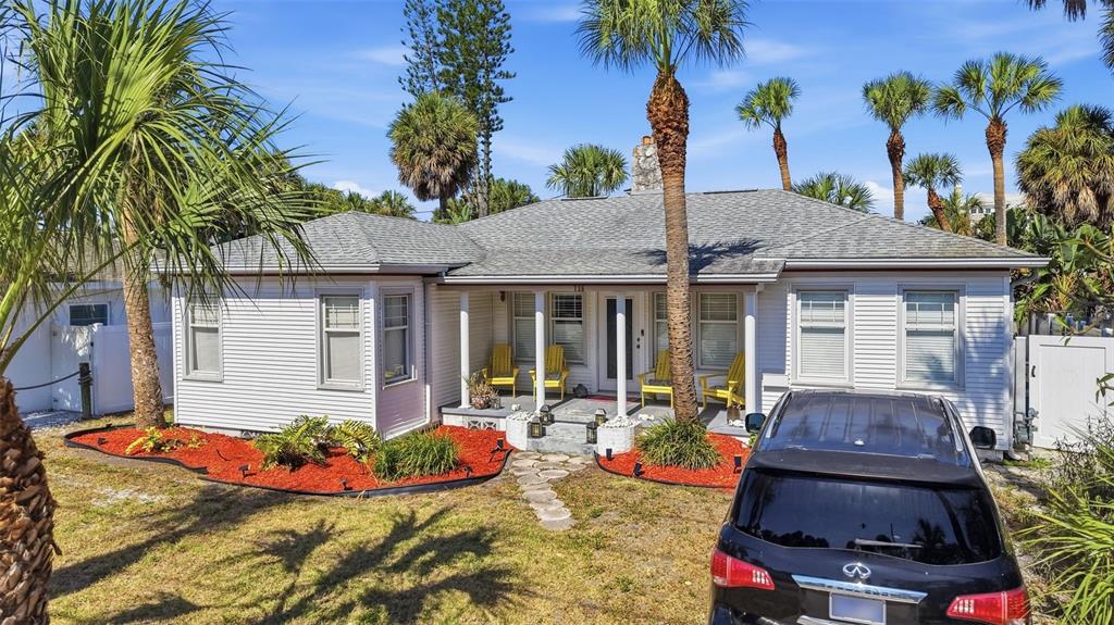 A single-story white house with a gray roof, front porch, and red mulch landscaping — 726 MANDALAY AVENUE, CLEARWATER BEACH, FL