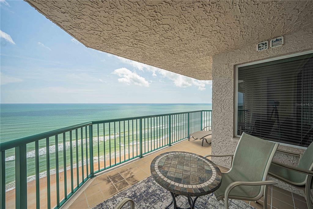 A balcony with a tiled floor, patio furniture, and a view of the ocean — 3315 S ATLANTIC AVENUE UNIT 1707, DAYTONA BEACH SHORES, FL