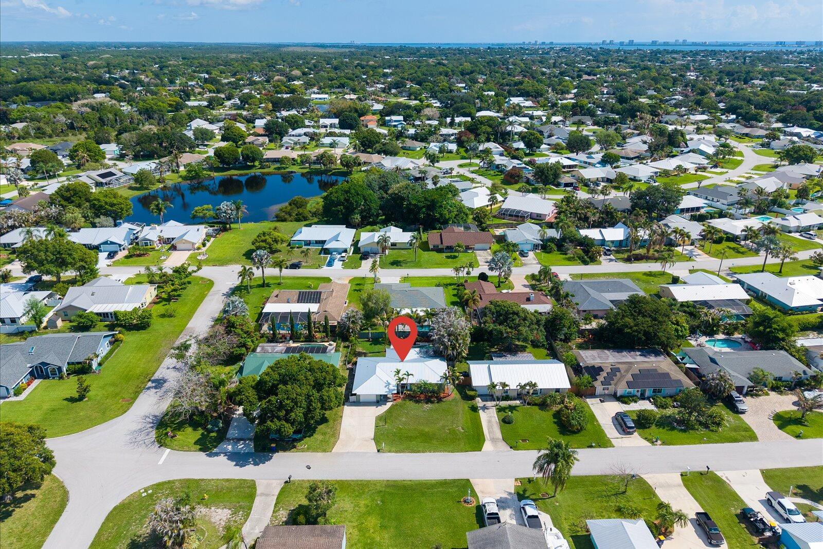 An aerial view of a suburban neighborhood featuring a house marked with a red pin — 687 NE Maranta Terrado, Jensen Beach FL 34957, JENSEN BEACH, FL