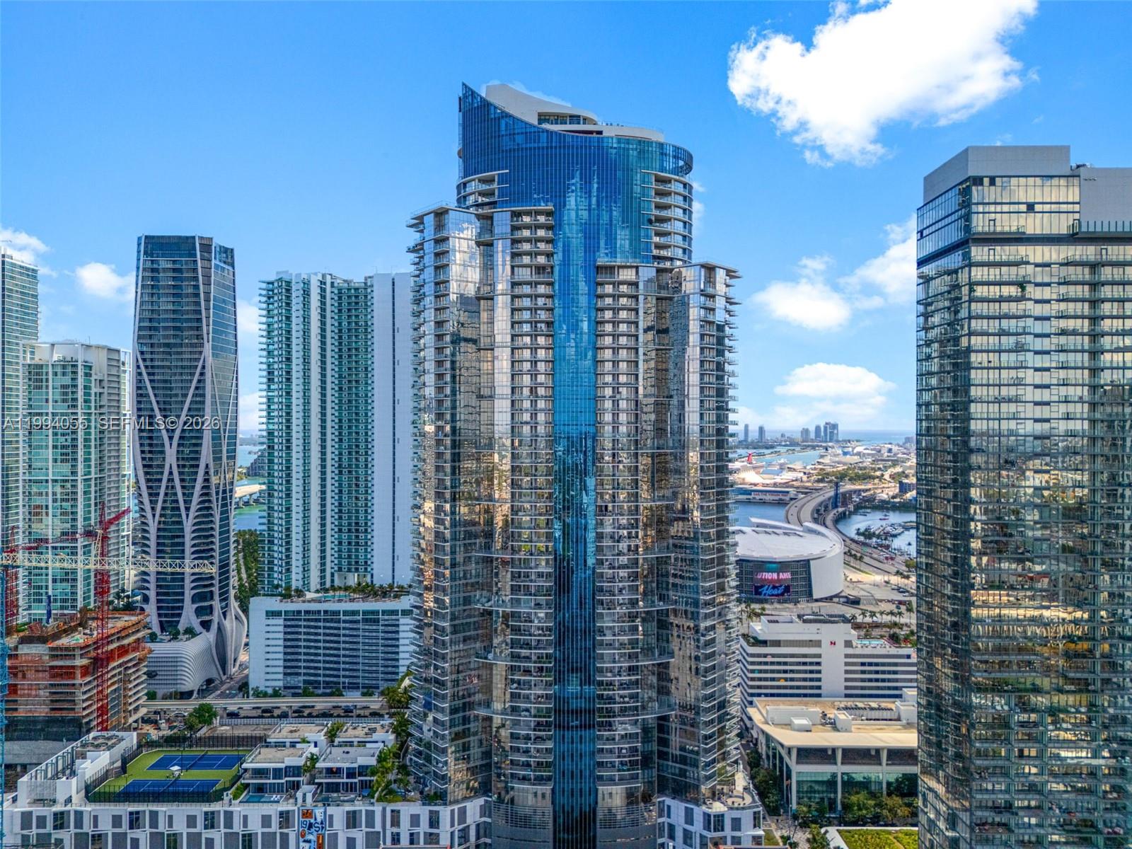 An exterior view of several modern glass skyscrapers in a dense urban city skyline — 851 NE 1st Ave # 1205, Miami FL 33132, MIAMI, FL