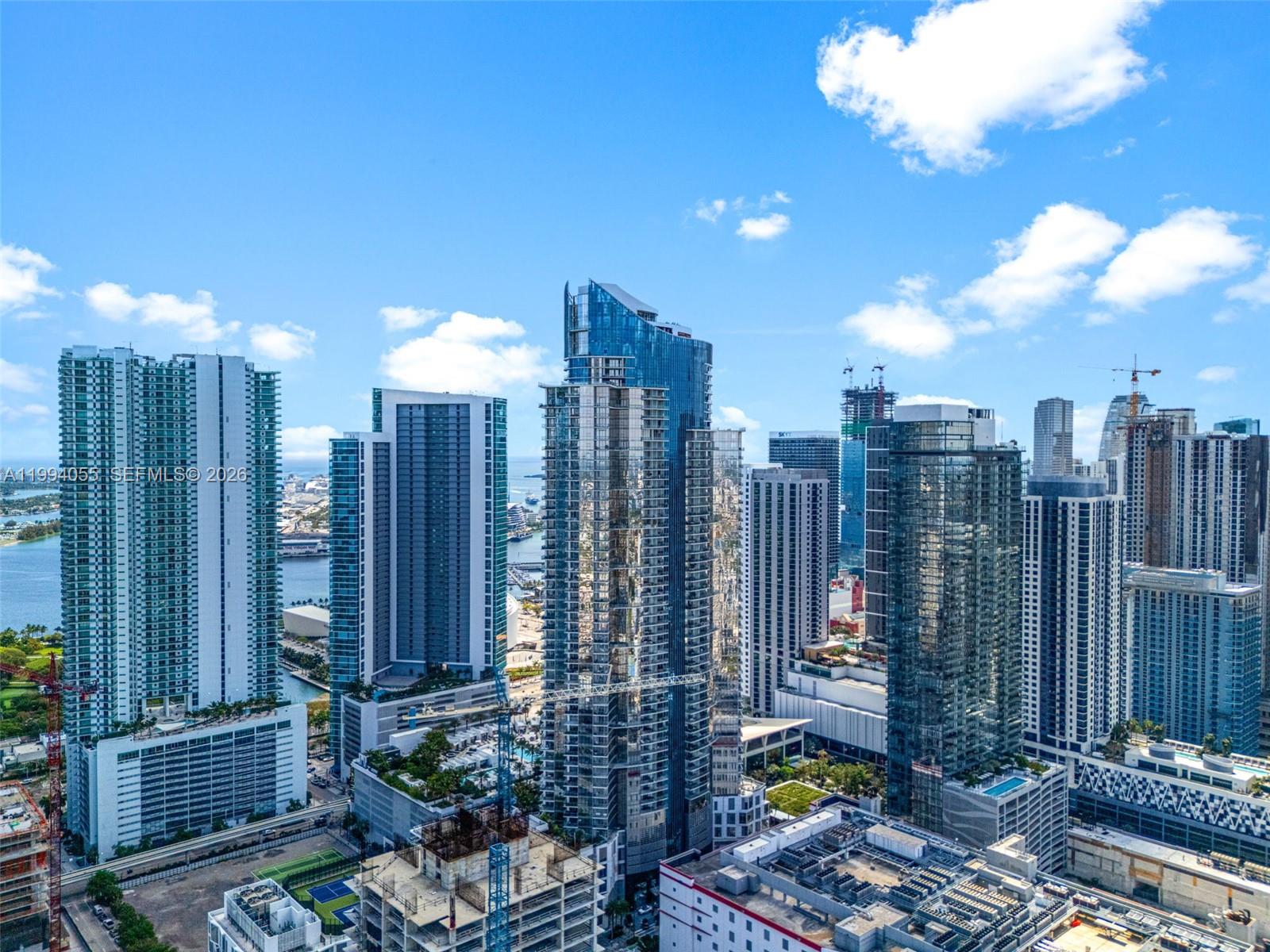 An aerial view of a dense urban skyline featuring numerous modern glass skyscrapers — 851 NE 1st Ave # 1205, Miami FL 33132, MIAMI, FL