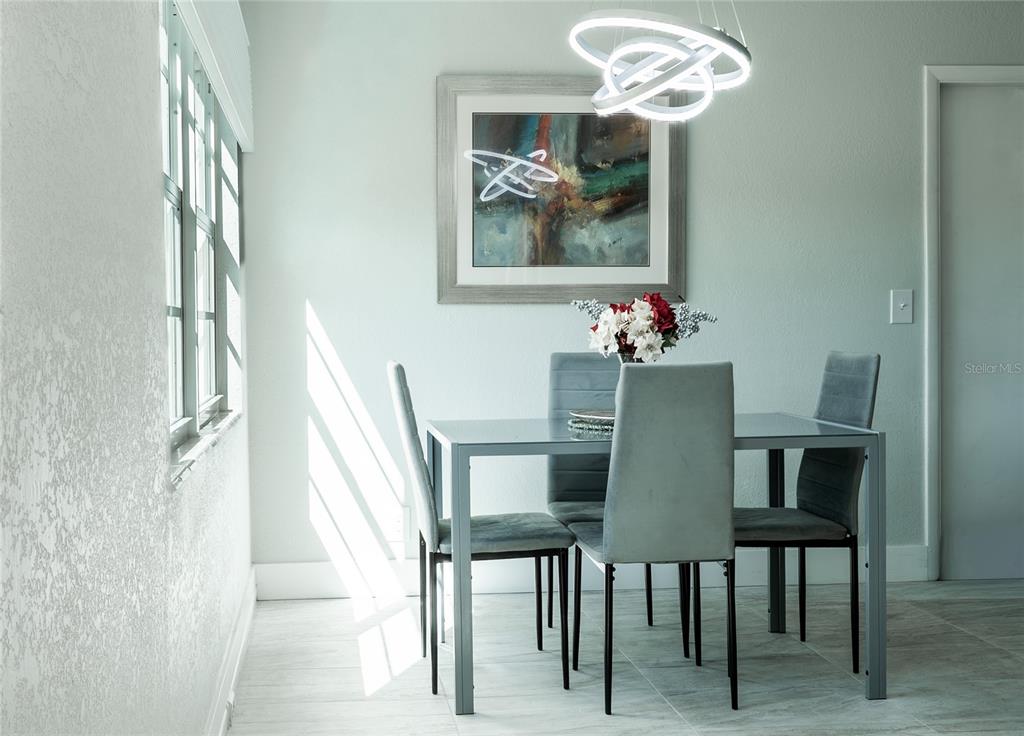 A dining area features a glass-top table, four gray chairs, and a modern light fixture — 592 FANSHAW O UNIT 592-O, BOCA RATON, FL