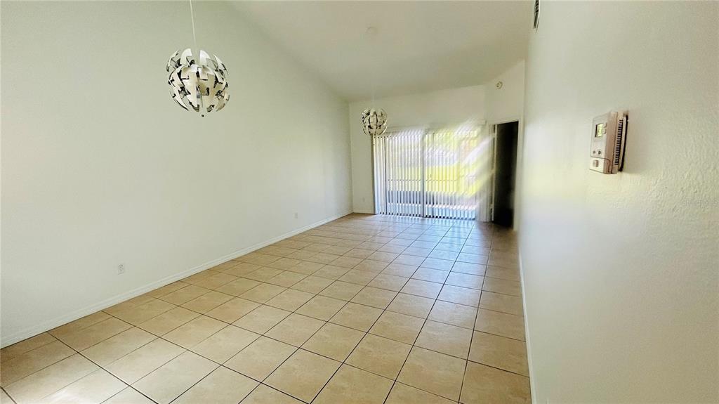 A two-story residential building with three garage doors and a large tree in the yard — 12121 AUGUSTA WOODS CIRCLE, ORLANDO, FL
