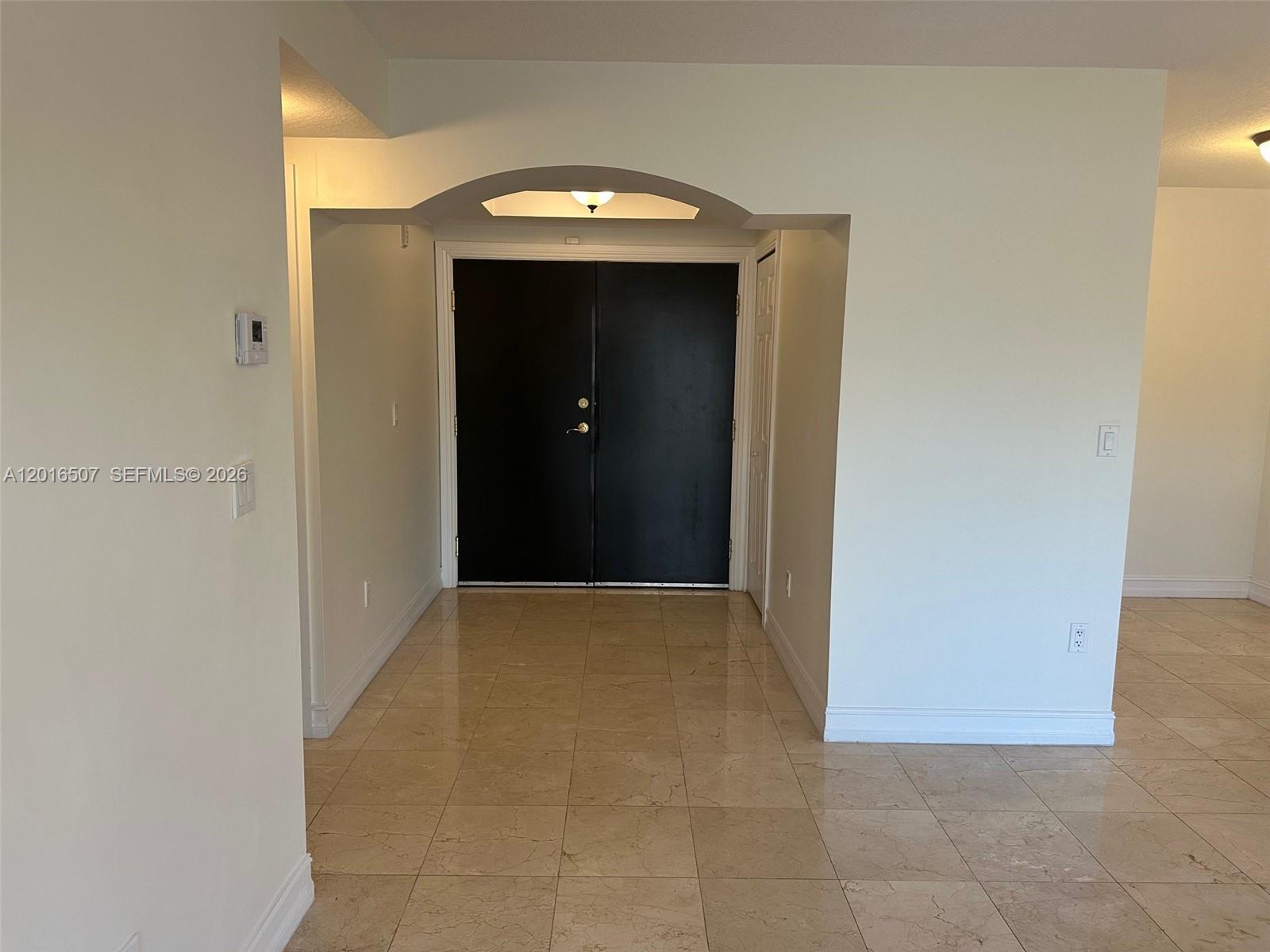 An entryway features beige tile flooring, white walls, and a black double-door entrance — 322 Madeira Ave # 302, Coral Gables FL 33134, CORAL GABLES, FL