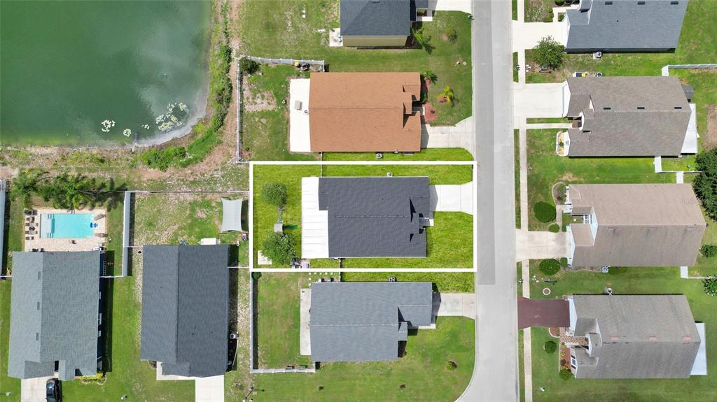 An aerial view shows a residential house with a dark roof and surrounding green lawn — 8335 ADELE ROAD, LAKELAND, FL