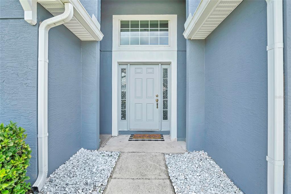 A front entryway features a light blue door with sidelights and a transom window — 8335 ADELE ROAD, LAKELAND, FL