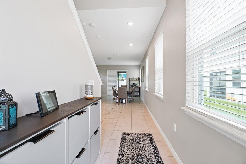 A hallway with tile flooring leads to a dining area with a view of the outdoors — 15187 WILLOW ARBOR CIRCLE, ORLANDO, FL