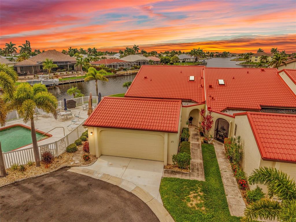 An aerial view shows waterfront townhomes with red roofs, a swimming pool, and docked boats — 3830 BAL HARBOR BOULEVARD UNIT #15, PUNTA GORDA, FL