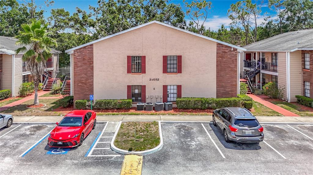 An exterior view of a two-story apartment building with a parking lot in front — 21032 VOYAGER BLVD UNIT 8, LAND O LAKES, FL