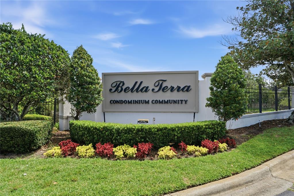 A sign for the Bella Terra Condominium Community stands in front of landscaped greenery — 2525 MAITLAND CROSSING WAY UNIT 304, ORLANDO, FL