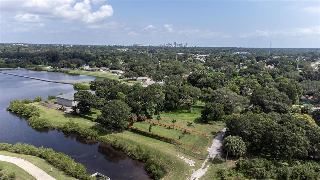 An aerial view shows a vacant, rectangular lot outlined in red next to a lake — 3834 29 AVENUE, ST PETERSBURG, FL