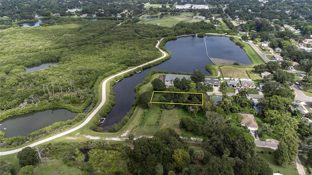 An aerial view shows a rectangular plot of land outlined in yellow near a lake — 3834 29 AVENUE, ST PETERSBURG, FL