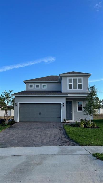 A two-story gray house features a two-car garage and a paved driveway — 4502 DAVOS DRIVE, CLERMONT, FL