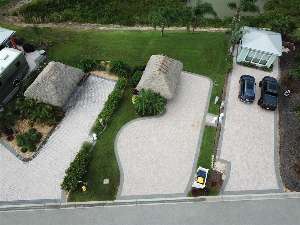 An aerial view shows three paved driveways, two tiki huts, and a small house — 3254 RED TAIL HAWK DRIVE, POLK CITY, FL