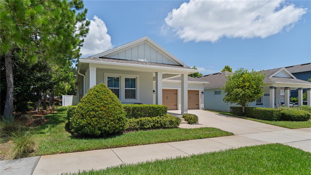 A single-story house with a light gray exterior, a two-car garage, and a landscaped yard — 15395 SUGAR CITRUS DRIVE, WINTER GARDEN, FL