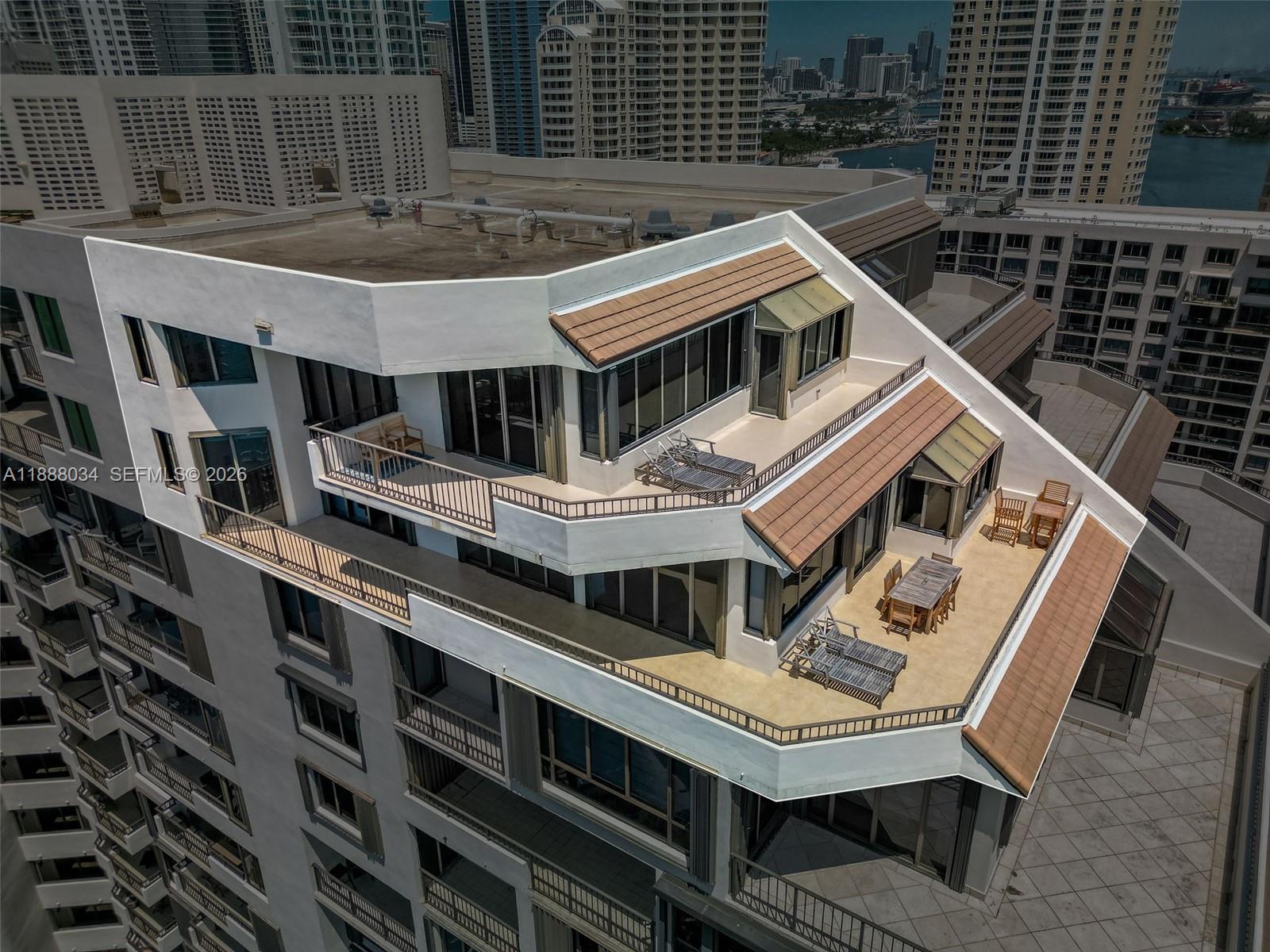 An aerial view of a high-rise building featuring multiple tiered terraces with outdoor furniture — 520 Brickell Key Drive # 03, Miami FL 33131, MIAMI, FL
