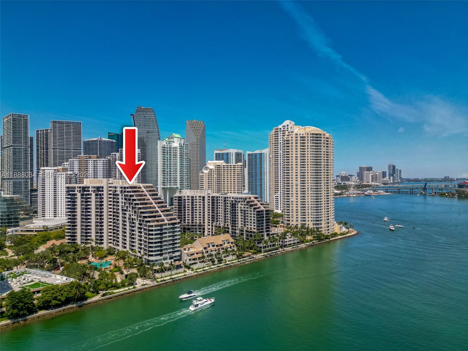 An aerial view shows a tiered waterfront residential building in Miami with a red arrow — 520 Brickell Key Drive # 03, Miami FL 33131, MIAMI, FL
