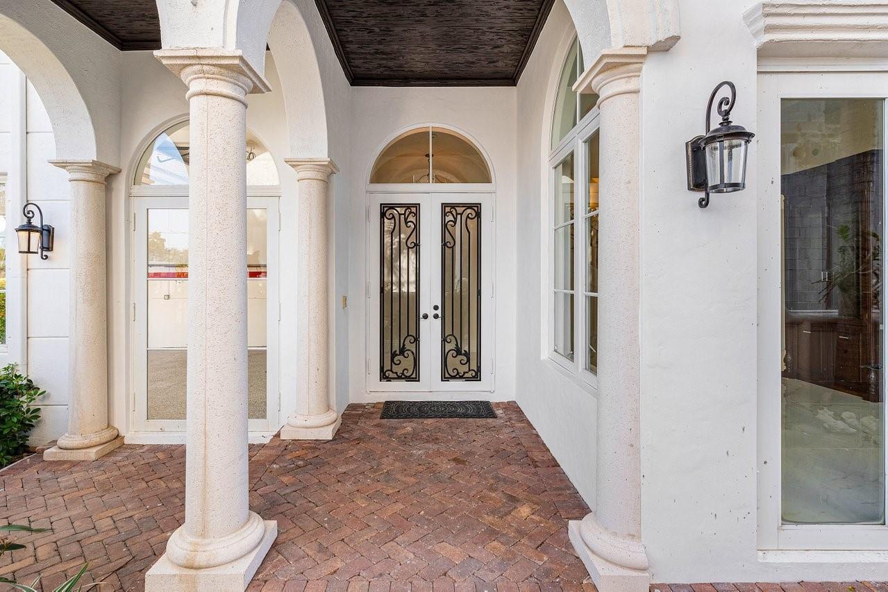 A covered brick entryway features white columns, arched windows, and a double front door — 549 NE 19th Avenue # C, Deerfield Beach FL 33441, DEERFIELD BEACH, FL