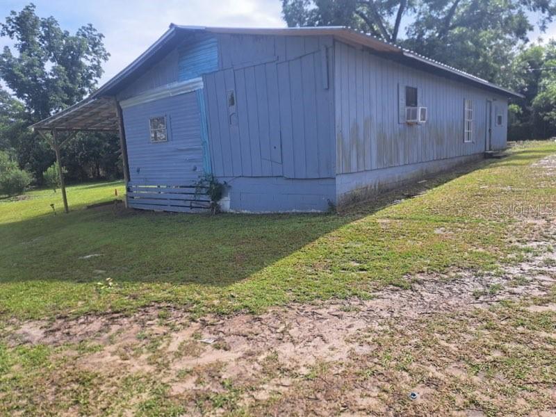 A blue, single-story mobile home with a metal roof and an attached carport — 4381 LEE ROAD, MARIANNA, FL