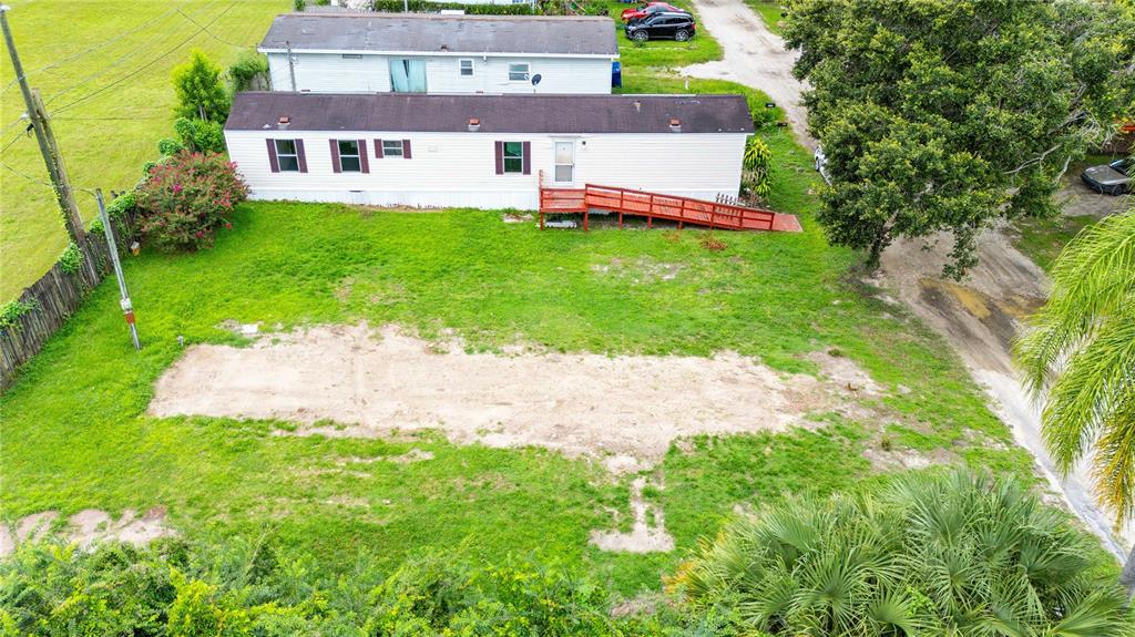 An aerial view shows a mobile home with a red ramp on a grassy lot — 39140 ORIENT AVENUE, ZEPHYRHILLS, FL