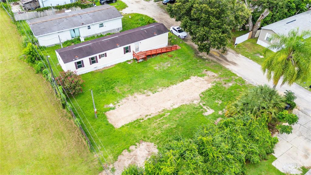 An aerial view shows a mobile home with a wooden ramp on a grassy lot — 39140 ORIENT AVENUE, ZEPHYRHILLS, FL