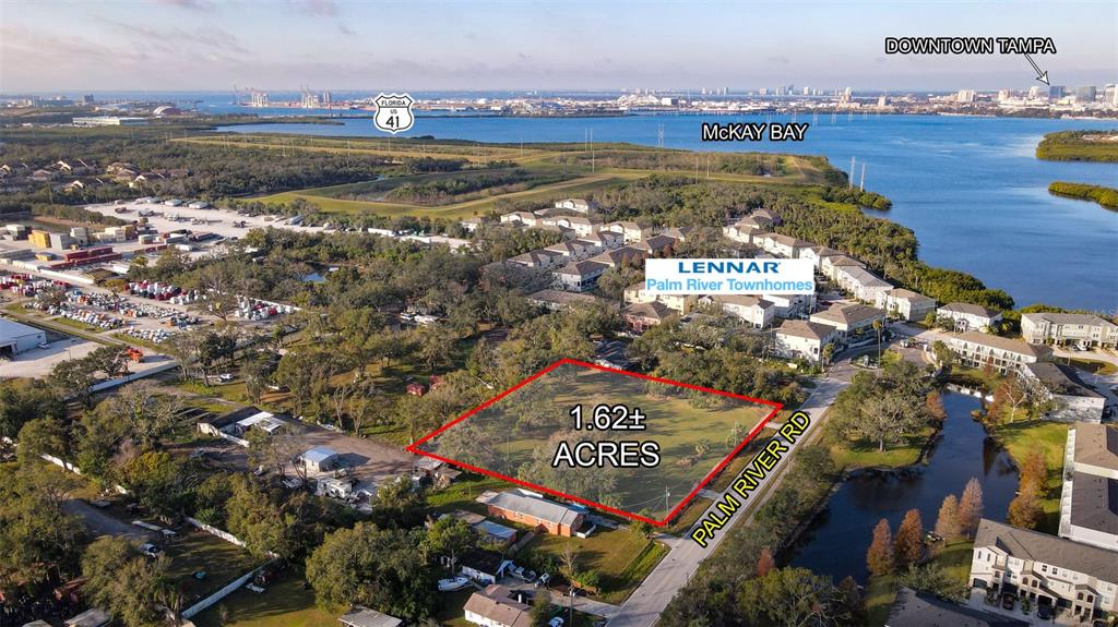 This aerial view shows a vacant 1.62-acre plot of land adjacent to a residential community — 4811 PALM RIVER ROAD, TAMPA, FL