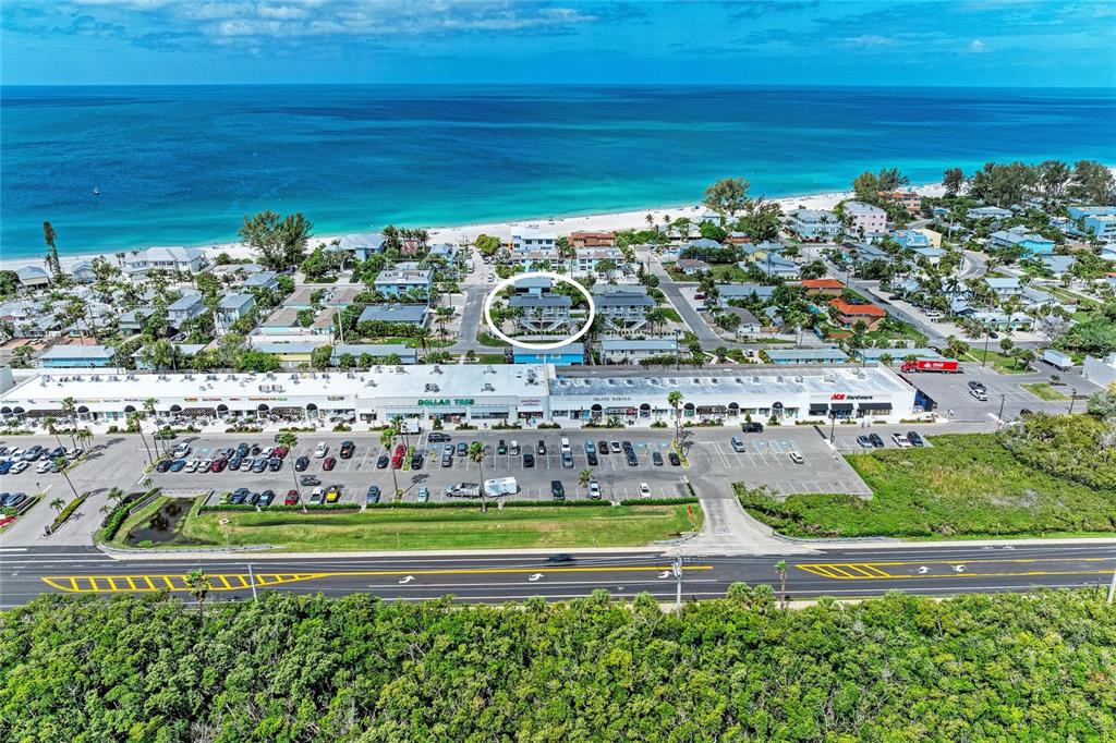 An aerial view shows a coastal shopping center, parking lot, and surrounding residential buildings — 3400 6TH AVENUE UNIT 6, HOLMES BEACH, FL