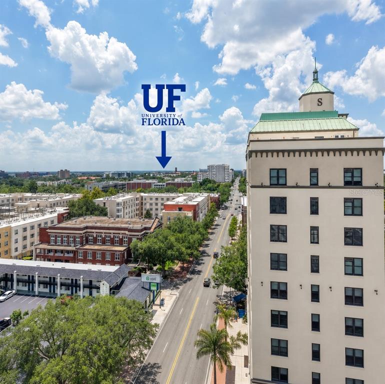 An aerial view shows a city street lined with buildings, trees, and a distant university — 408 W UNIVERSITY AVENUE UNIT 7B, GAINESVILLE, FL