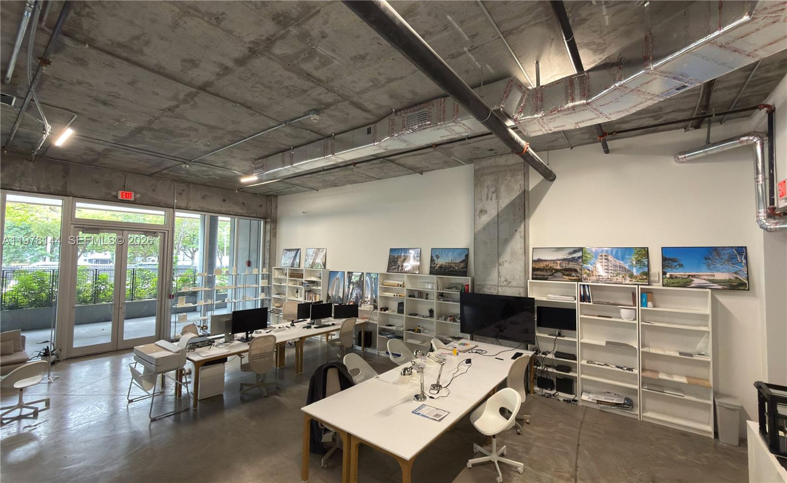 An office space features exposed concrete ceilings, white walls, workstations, and floor-to-ceiling windows — 2900 SW 28th Ln # C5, Miami FL 33133, MIAMI, FL