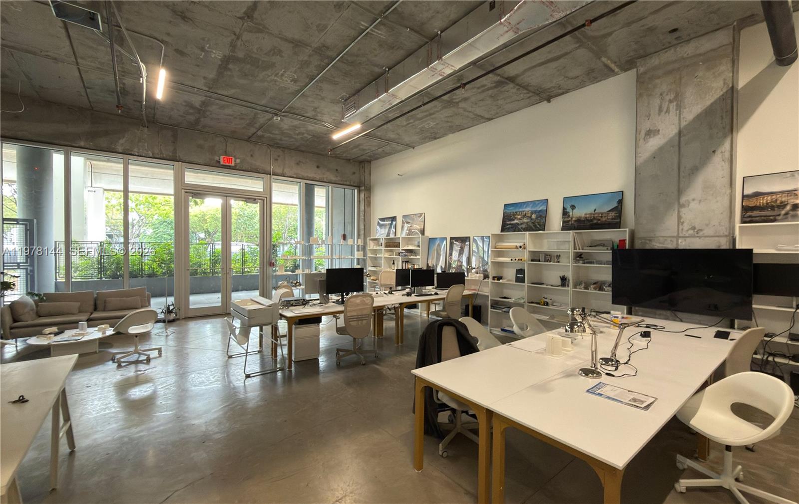 An open-plan office space features concrete ceilings, large windows, and multiple workstations — 2900 SW 28th Ln # C5, Miami FL 33133, MIAMI, FL