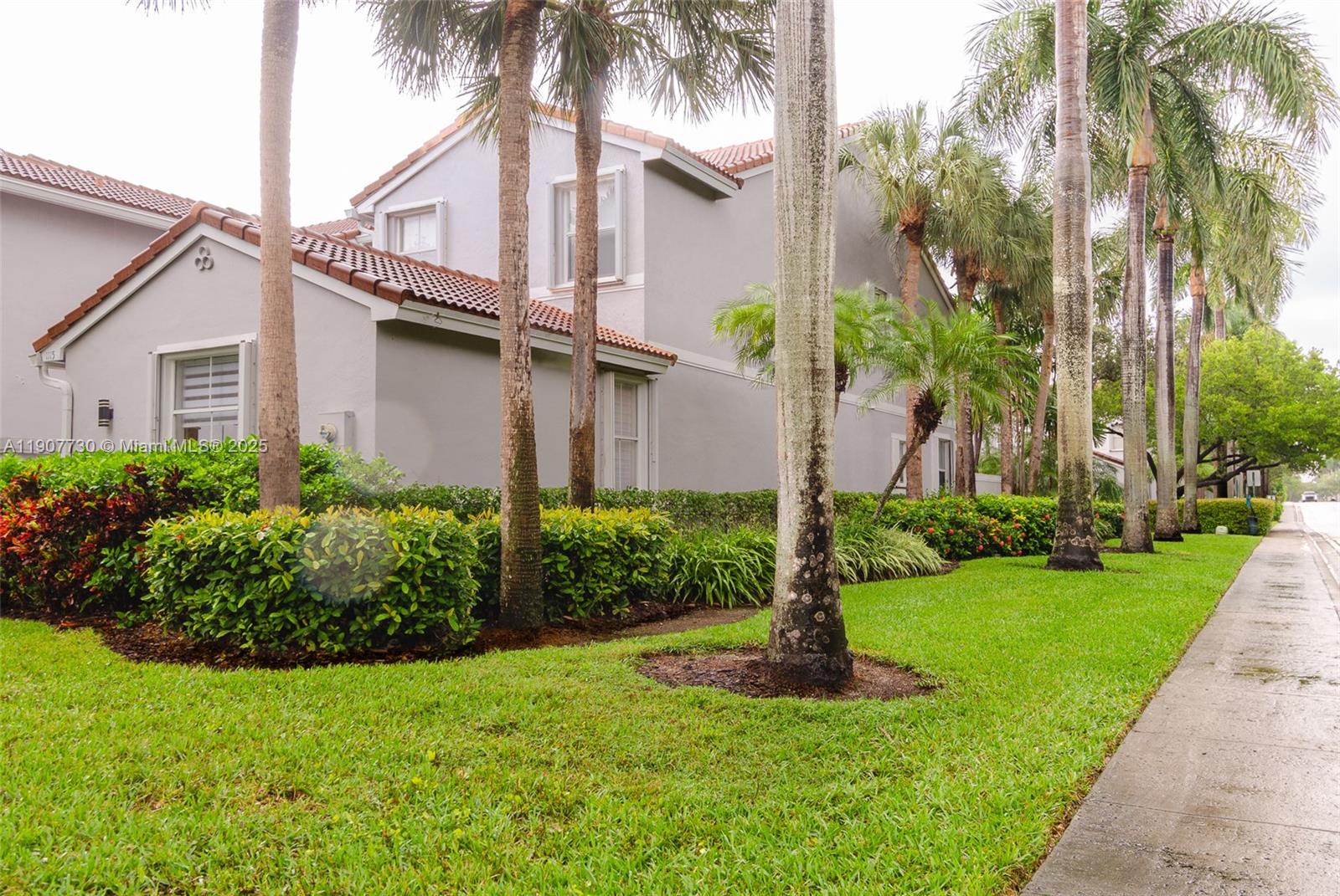 A two-story residential building with a tiled roof is surrounded by palm trees and landscaping — 1115 Cherrypalm, Hollywood FL 33019, HOLLYWOOD, FL
