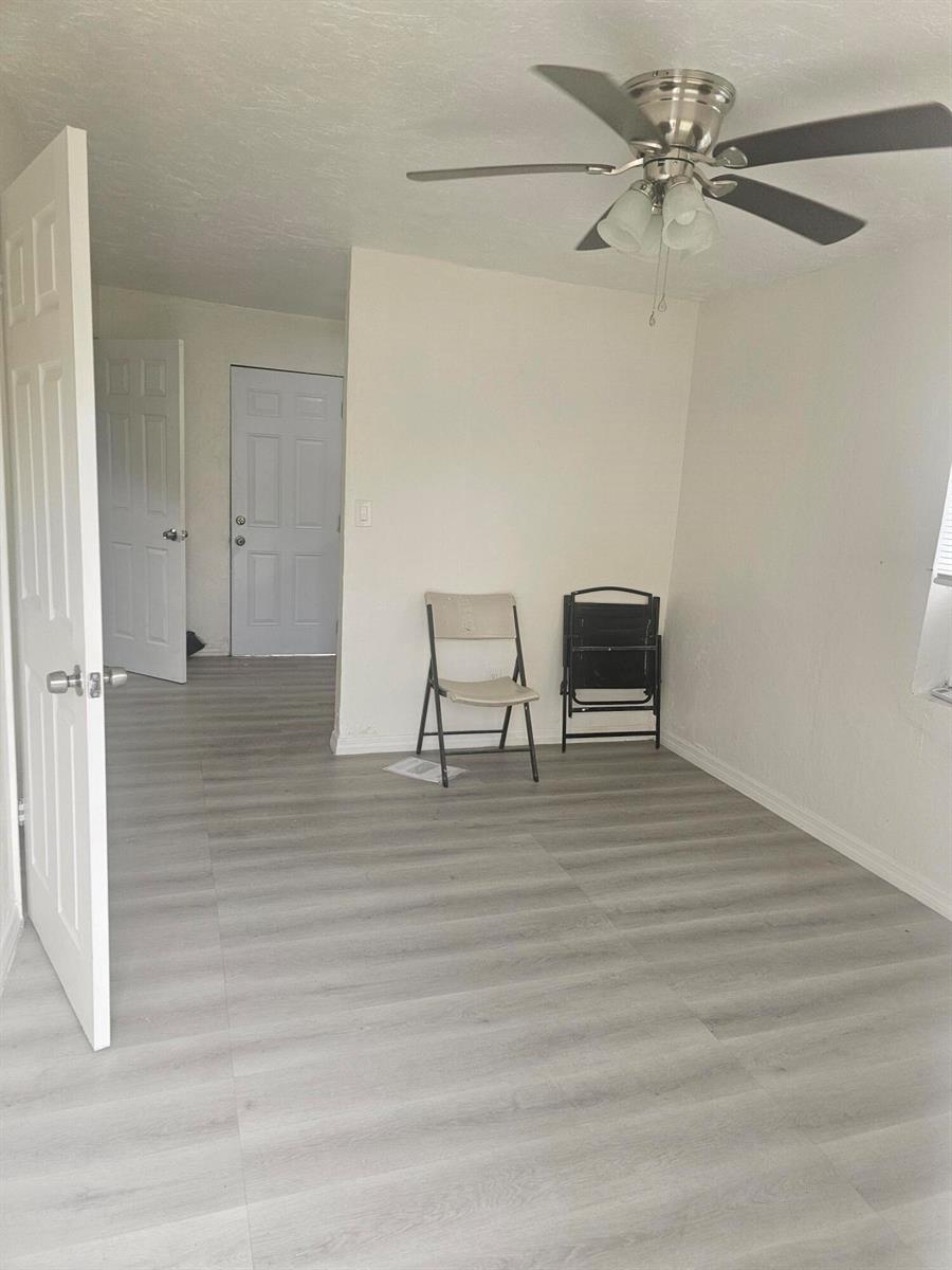 A room with light wood-look flooring, a ceiling fan, and two folding chairs — 505 NW 16th Avenue, Pompano Beach FL 33069, POMPANO BEACH, FL