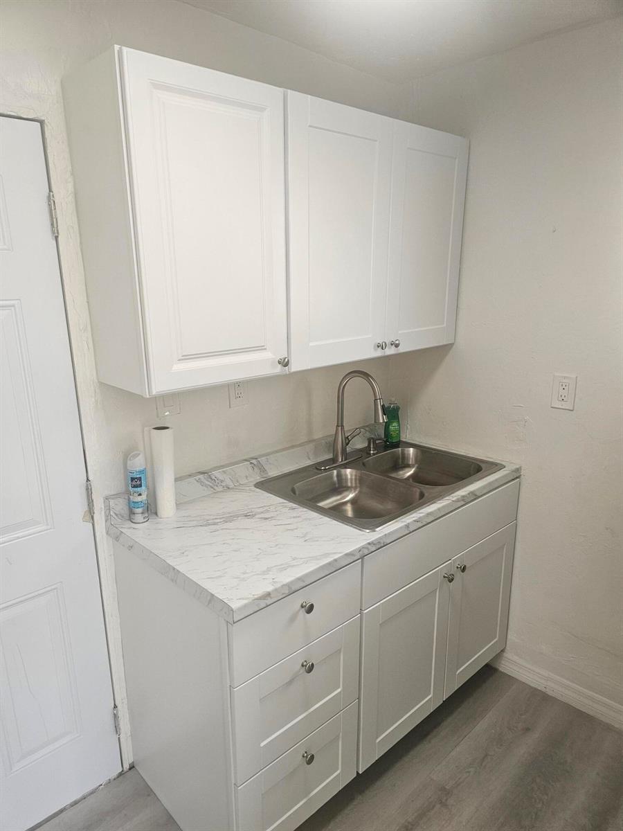 A small kitchen area features white cabinets, a marble-patterned countertop, and a stainless steel sink — 505 NW 16th Avenue, Pompano Beach FL 33069, POMPANO BEACH, FL