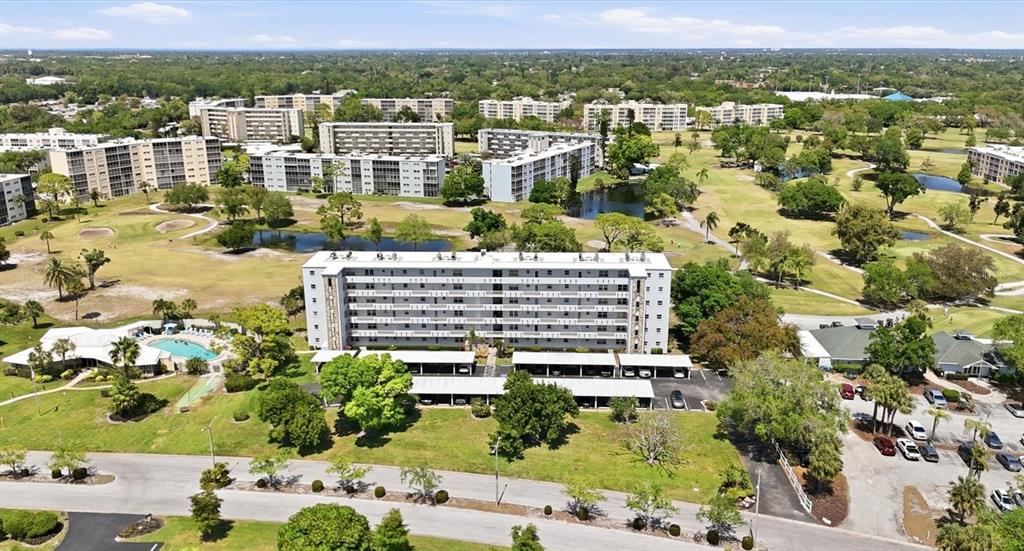 An aerial view shows a multi-story apartment building surrounded by a golf course and ponds — 4240 IRONWOOD CIRCLE UNIT 406AA, BRADENTON, FL