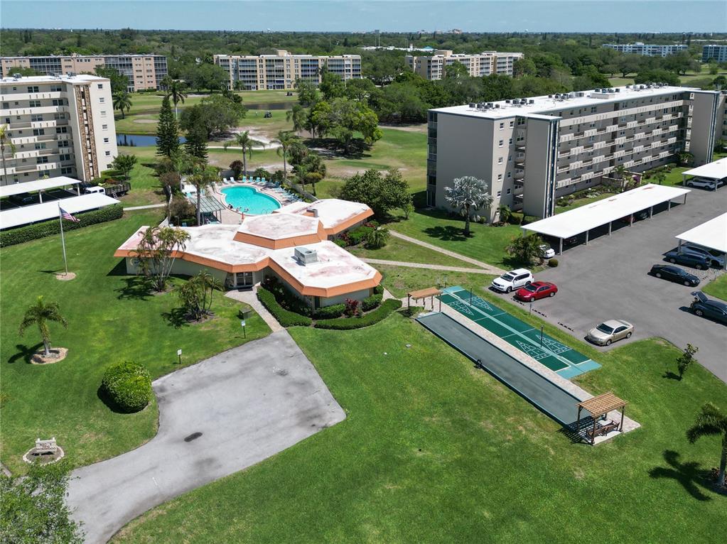 An aerial view shows a community clubhouse with a pool, shuffleboard courts, and parking lots — 4240 IRONWOOD CIRCLE UNIT 406AA, BRADENTON, FL