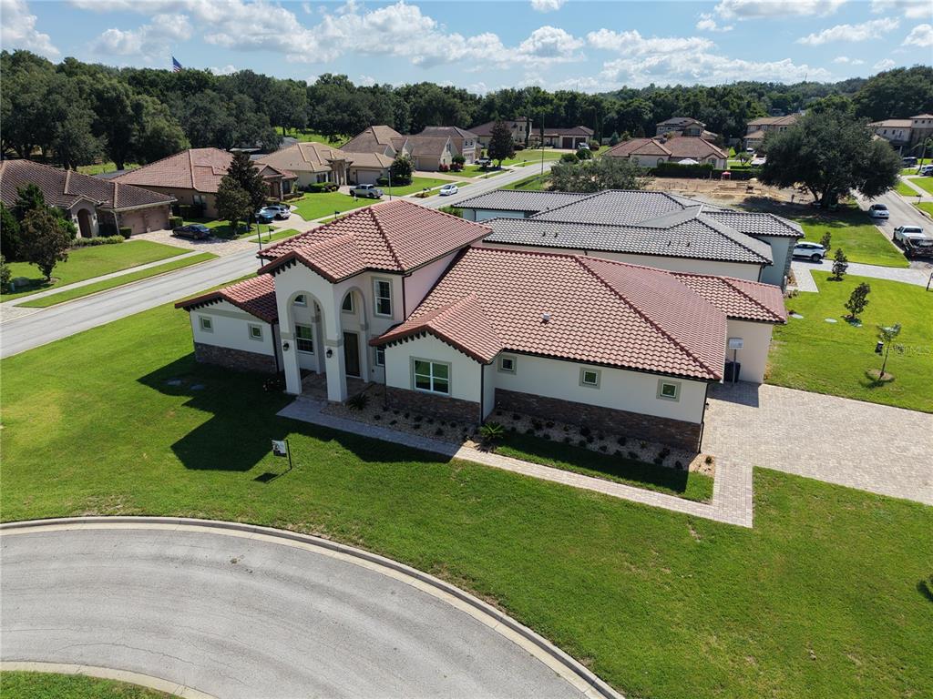 An aerial view of a single-story house with a tile roof and stone accents — 12926 BRUNELLO CIRCLE, CLERMONT, FL
