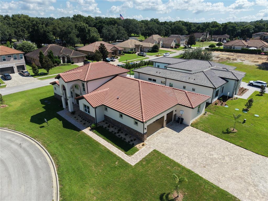An aerial view shows a single-story house with a terracotta tile roof and paved driveway — 12926 BRUNELLO CIRCLE, CLERMONT, FL