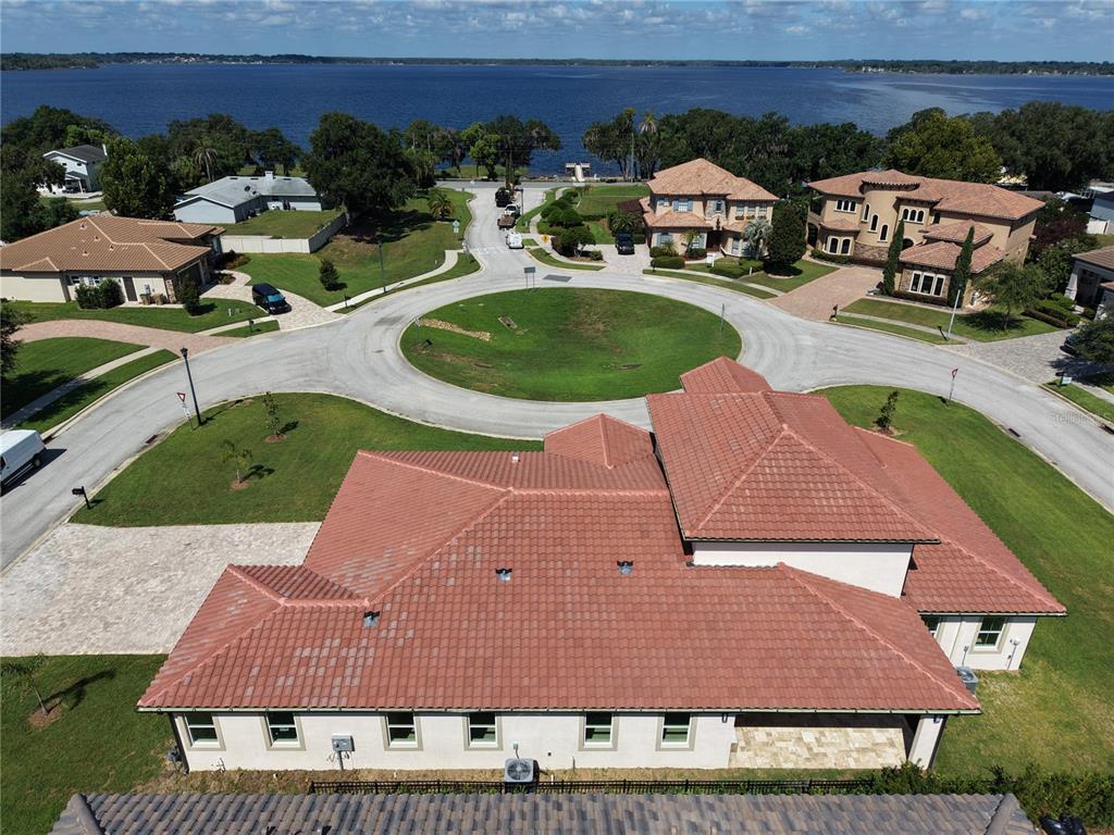 An aerial view shows a large house with a red tile roof near a cul-de-sac — 12926 BRUNELLO CIRCLE, CLERMONT, FL