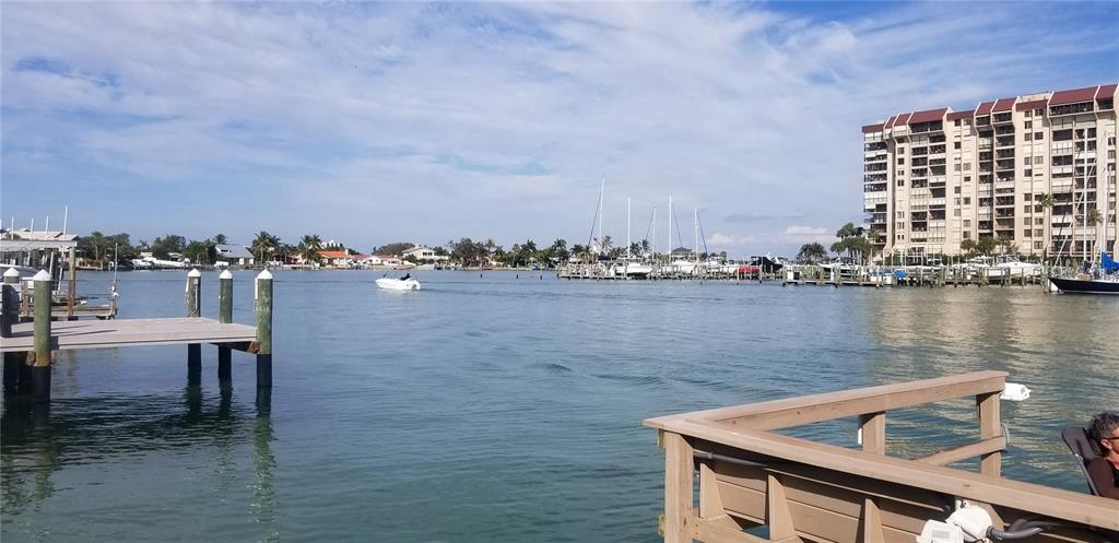 A view of a waterway with docks, boats, and a large apartment building — 9715 HARRELL AVENUE UNIT 14, TREASURE ISLAND, FL