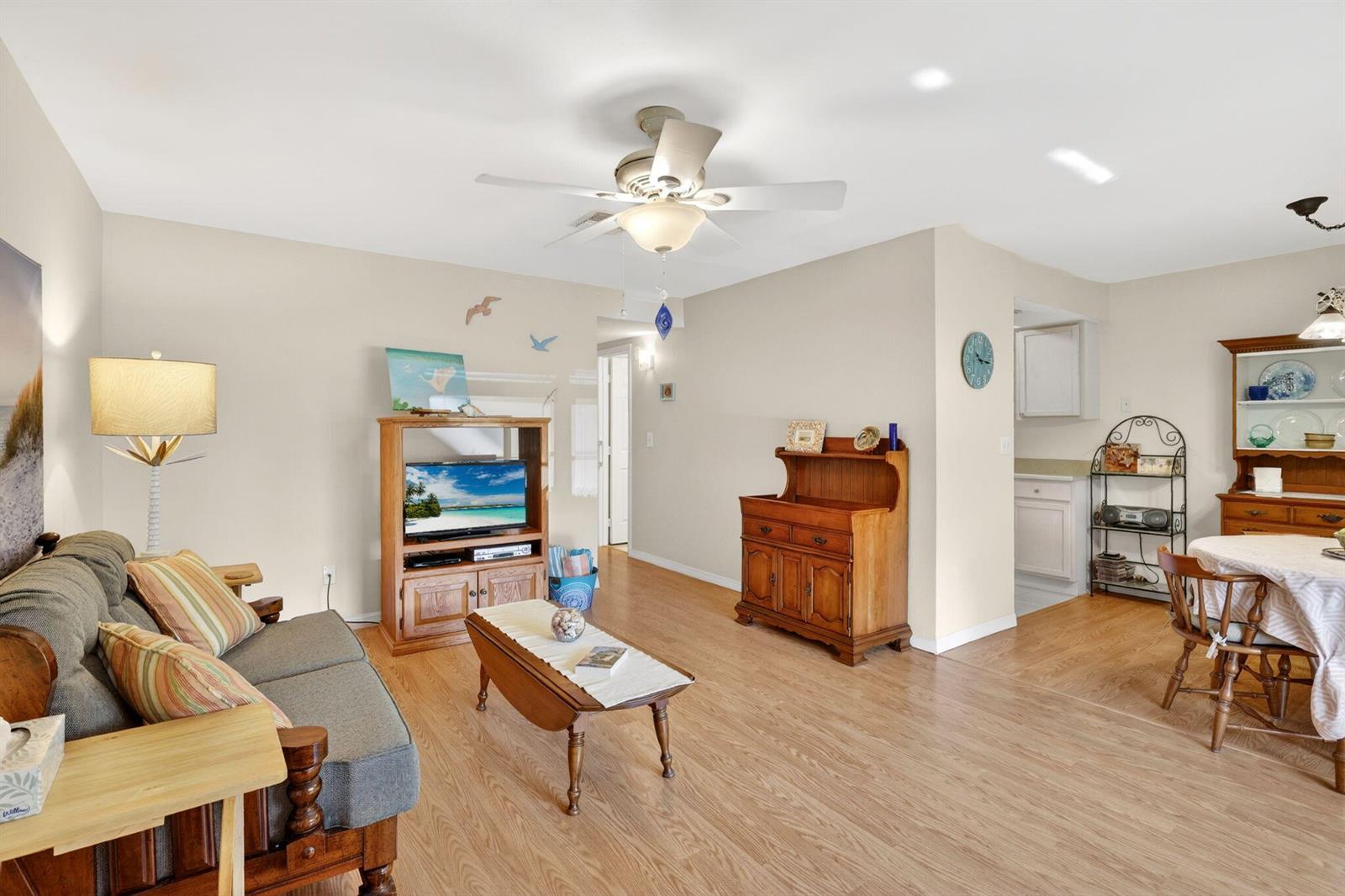A living room and dining area with light wood flooring, a ceiling fan, and furniture — 2929 SE Ocean Boulevard # M4, Stuart FL 34996, STUART, FL