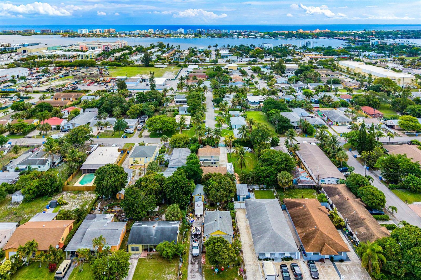 An aerial view shows a residential neighborhood with houses, palm trees, and a distant bay — 613 N 5th Street, Lantana FL 33462, LANTANA, FL