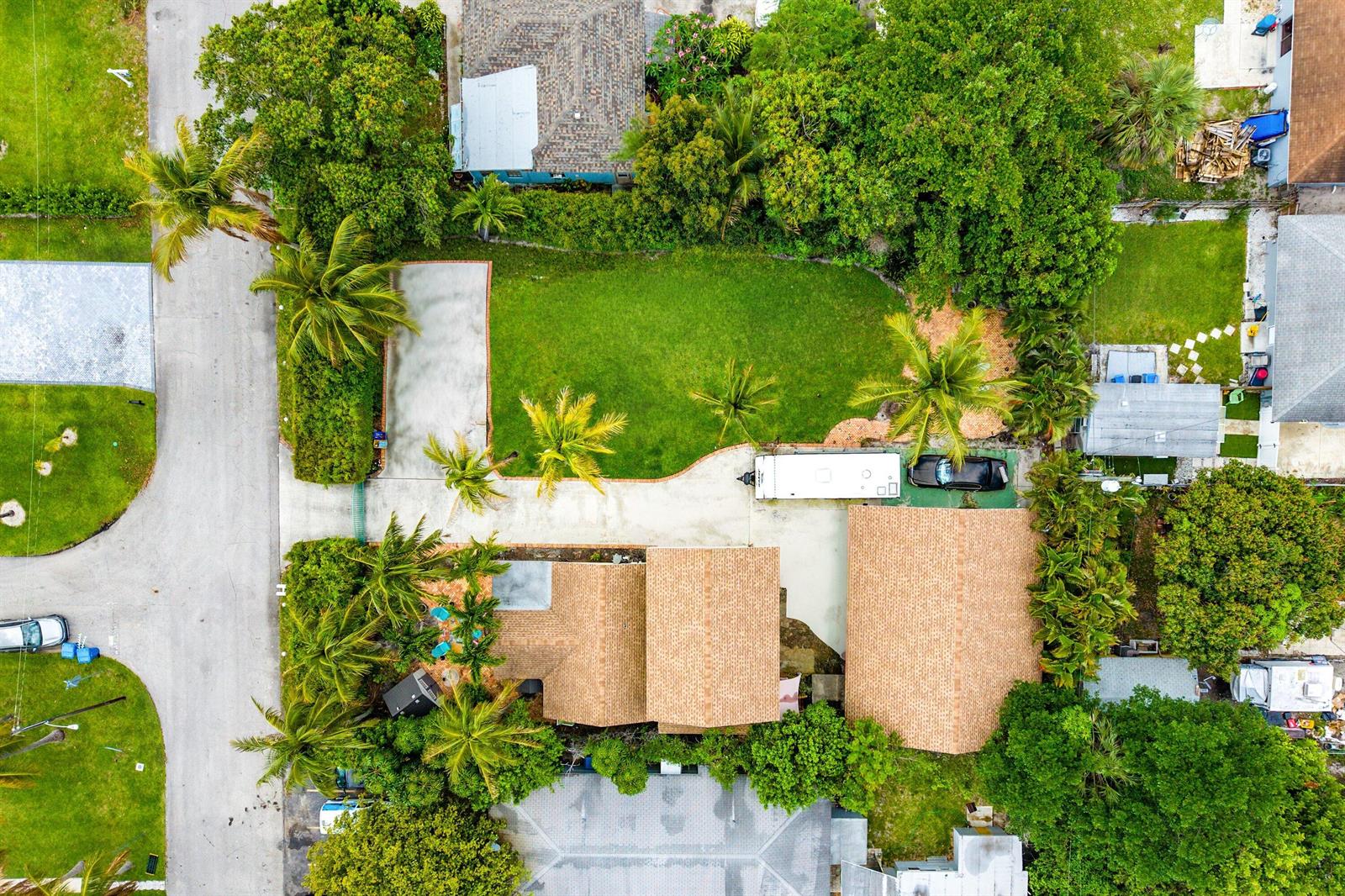 An aerial view shows a house with a large backyard, palm trees, and a driveway — 613 N 5th Street, Lantana FL 33462, LANTANA, FL